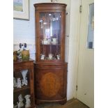 A reproduction feather banded burr yew-wood side cabinet, with three glazed doors and a plinth base,