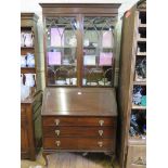 A 1930s mahogany bureau bookcase, with arched glazing bars, sloping fall enclosing pigeon holes