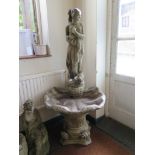 A reconstituted stone garden water feature, of a Classical figure over a shell form basin on a