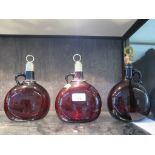 Three 19th century brown glass moon flasks, two with silver plated stoppers and spirit labels,