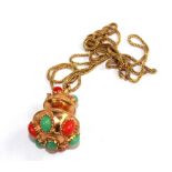 A gold pendant set with coral and aventurine on 18 carat gold chain