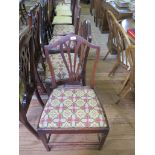 A set of four late George III mahogany shield back dining chairs with pierced vase shape splats,