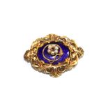 A Victorian brooch decorated in blue enamel with seed pearl and garnet