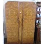 A two piece 1920s burr walnut bedroom suite, comprising wardrobe and dressing table, wardrobe