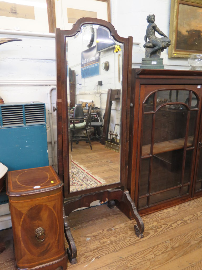 A 1920s mahogany cheval mirror, the shaped bevelled plate on carved scroll feet, 167.5cm high