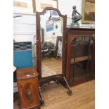 A 1920s mahogany cheval mirror, the shaped bevelled plate on carved scroll feet, 167.5cm high