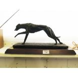 A bronzed figure of a greyhound wearing a number one bib, 42cm long