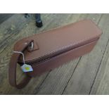 A Tan leather travel single wine bottle case, interior padded suede with pocket including