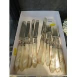 A set of silver knives and forks with silver blades and tines and mother of pearl handles