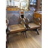 A pair of Glastonbury type carved oak chairs, with lozenge carved backs and rosette carved arms (2)