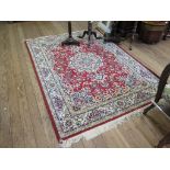 A Keshan style carpet, the red field with central medallion and blue spandrels, with allover