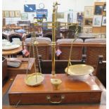 A set of brass balances, mounted on a fitted timber box, with Troy ounce weights 70cm high