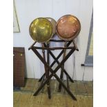 Three copper and brass warming pans and a folding wood stand