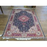 *A Keshan style rug, the red medallion on a dark blue field with white spandrels and multiple