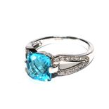 An 18 carat white gold ring set with central blue topaz with diamond shoulders