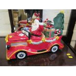 A ceramic model of Father Christmas in a car filled with toys, the car forming a lidded box, the