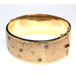 A gem set 9 carat gold bangle