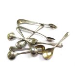 A collection of seven silver salt and mustard spoons and a pair of silver sugar tongs