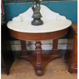 A Victorian walnut washstand, the demi lune marble top over a fluted turned support and