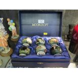 A set of six Moorcroft egg cups, each depicting a different farm animal, in a presentation box