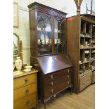 A 1930s mahogany bureau bookcase, with arched glazing bars over a sloping fall enclosing pigeon