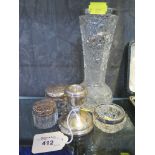 A cut glass vase with silver rim, three silver topped toilet jars and a small silver candlestick