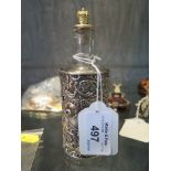 A collection of four perfume bottles to include a large silver topped cranberry bottle with stopper,