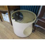 A 1970s fawn plywood circular occasional table, with glass top and concave shelves 54cm diameter