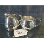 A small silver cream jug together with a matching two handled sugar basin, mixed dates