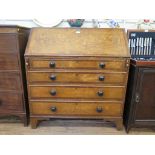 A 19th century crossbanded oak bureau, the sloping fall enclosing a fitted interior over four long