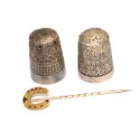 A 9 carat gold horse shoe pin and two thimbles