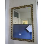An oak framed bevelled oval wall mirror 74cm x 50cm, two other giltwood framed rectangular wall
