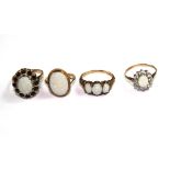 A collection of four 9 carat gold rings set with opals