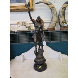 A spelter female figure of an ironworker, arm aloft, on a rocky base and socle, 69cm high