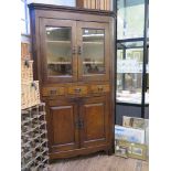 An early 20th century corner cabinet, with twin glazed doors over three drawers and a pair of