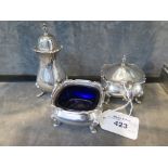 A three piece silver cruet complete with blue liners on four bun feet