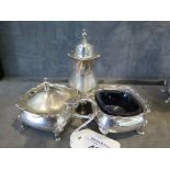 A three piece silver cruet complete with blue liners on four bun feet