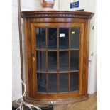 An oak hanging corner cupboard, with dentil cornice and glazed door, 61.5cm wide, 75cm high