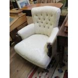 A late Victorian cream damask covered lady's armchair, with button back and ring turned tapering