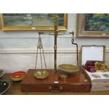 A set of brass balances, mounted on a fitted timber box, with Troy ounce weights 70cm high