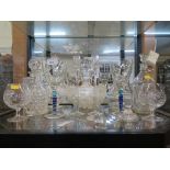 A glass ship's decanter, five other decanters, a glass bowl, a pair of candlesticks and drinking