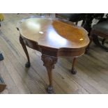 A 1920s burr walnut coffee table, with shaped top on shell carved cabriole legs with hairy paw feet