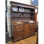 A George III oak dresser and rack, the three tier rack with five drawers over three frieze and two