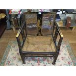 A 1920s black lacquered and caned armchair, with chinoserie decoration