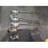 A set of silver tea spoons with the name Singapore within the handles