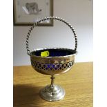 A silver plated sugar basket on single foot with blue glass liner