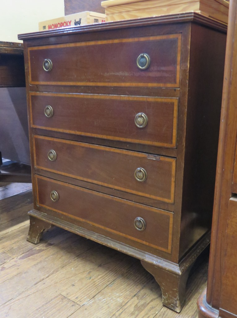 A mahogany and satinwood crossbanded chest of drawers, with four long drawers on ogee bracket