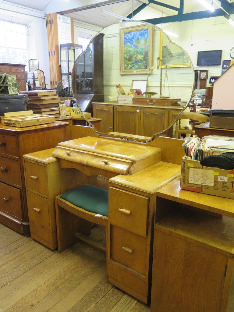 An Art Deco burr oak dressing table, the shaped mirror above a shaped drawer and a kneehole