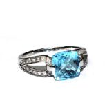 An 18 carat white gold ring set with central blue topaz with diamond shoulders