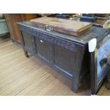 An 18th century oak coffer, the hinged top over a triple panel front with interlaced carving 132cm